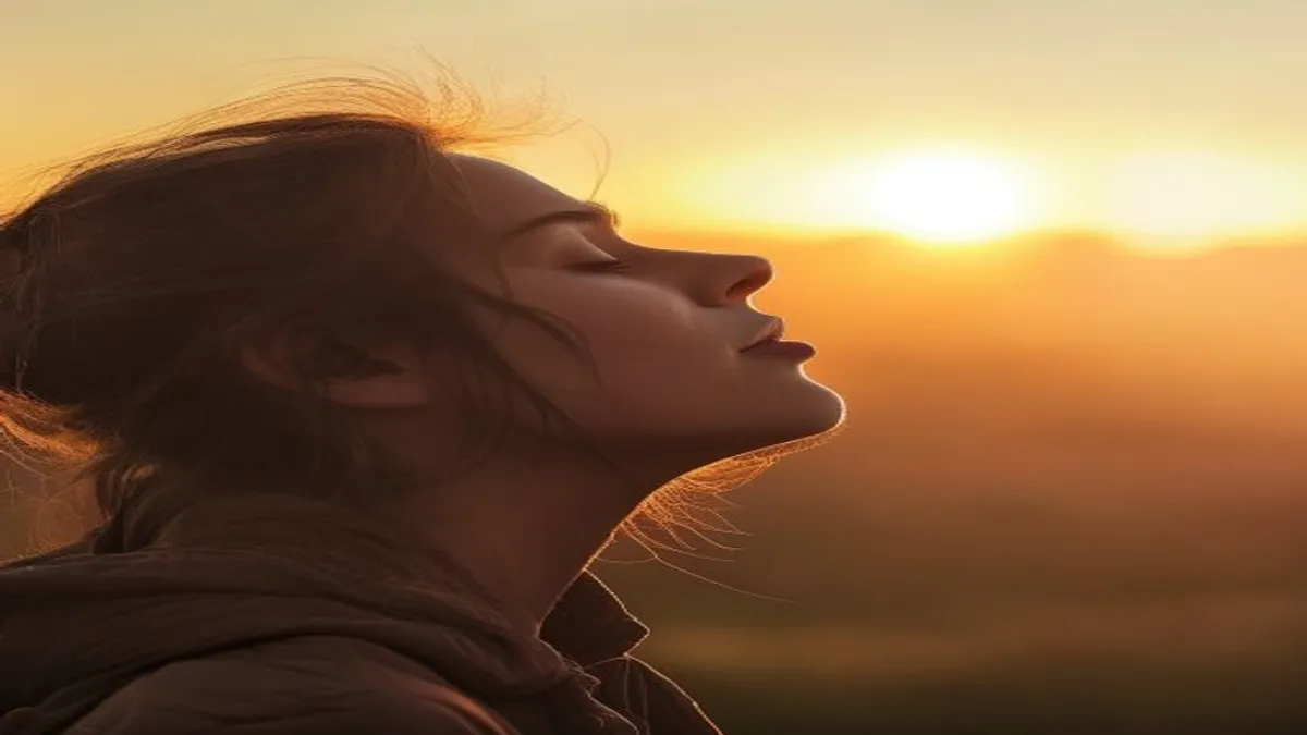 Person breathing deeply at sunrise overlook.